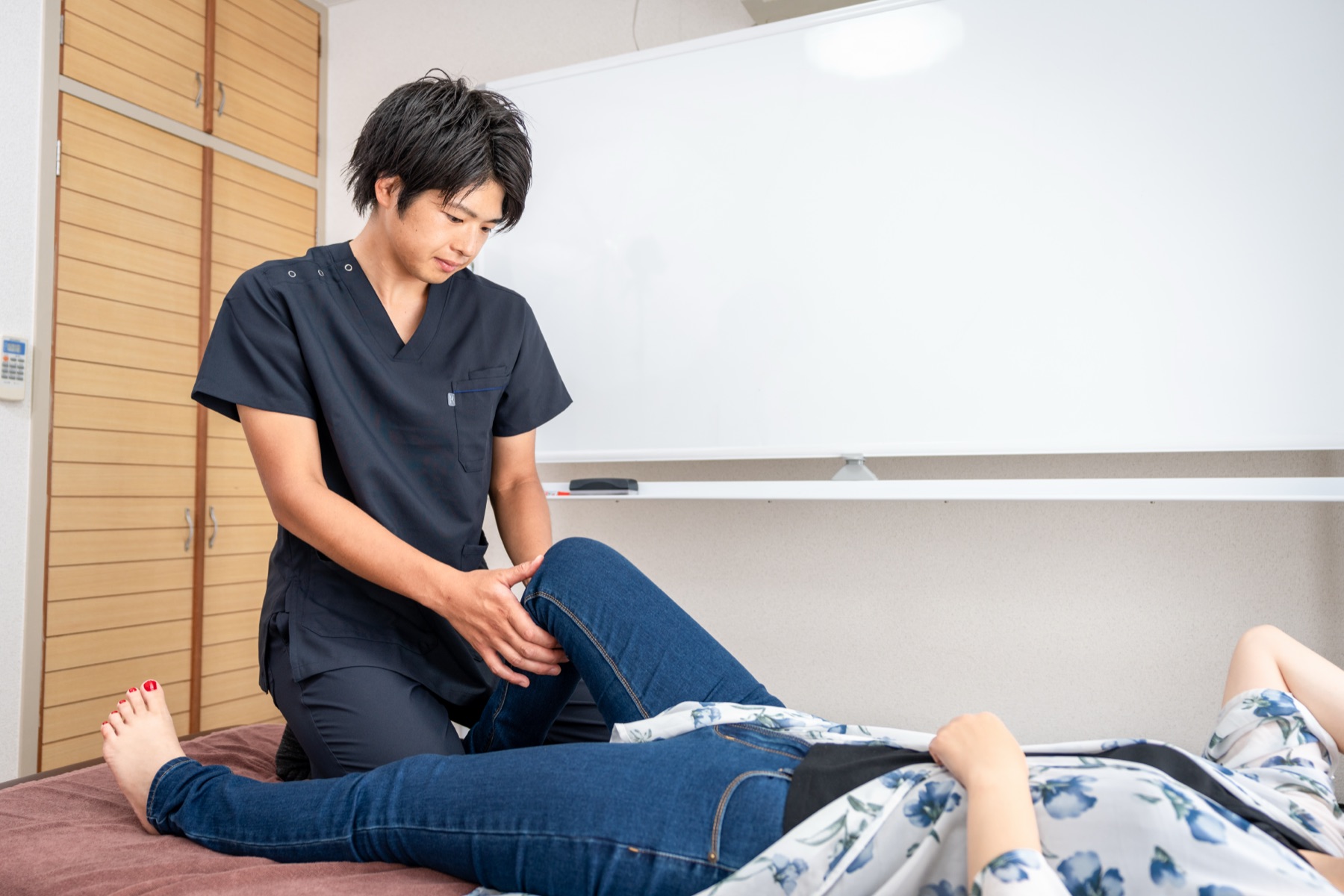 施術室で院長が来院者の脚の状態を確かめている様子